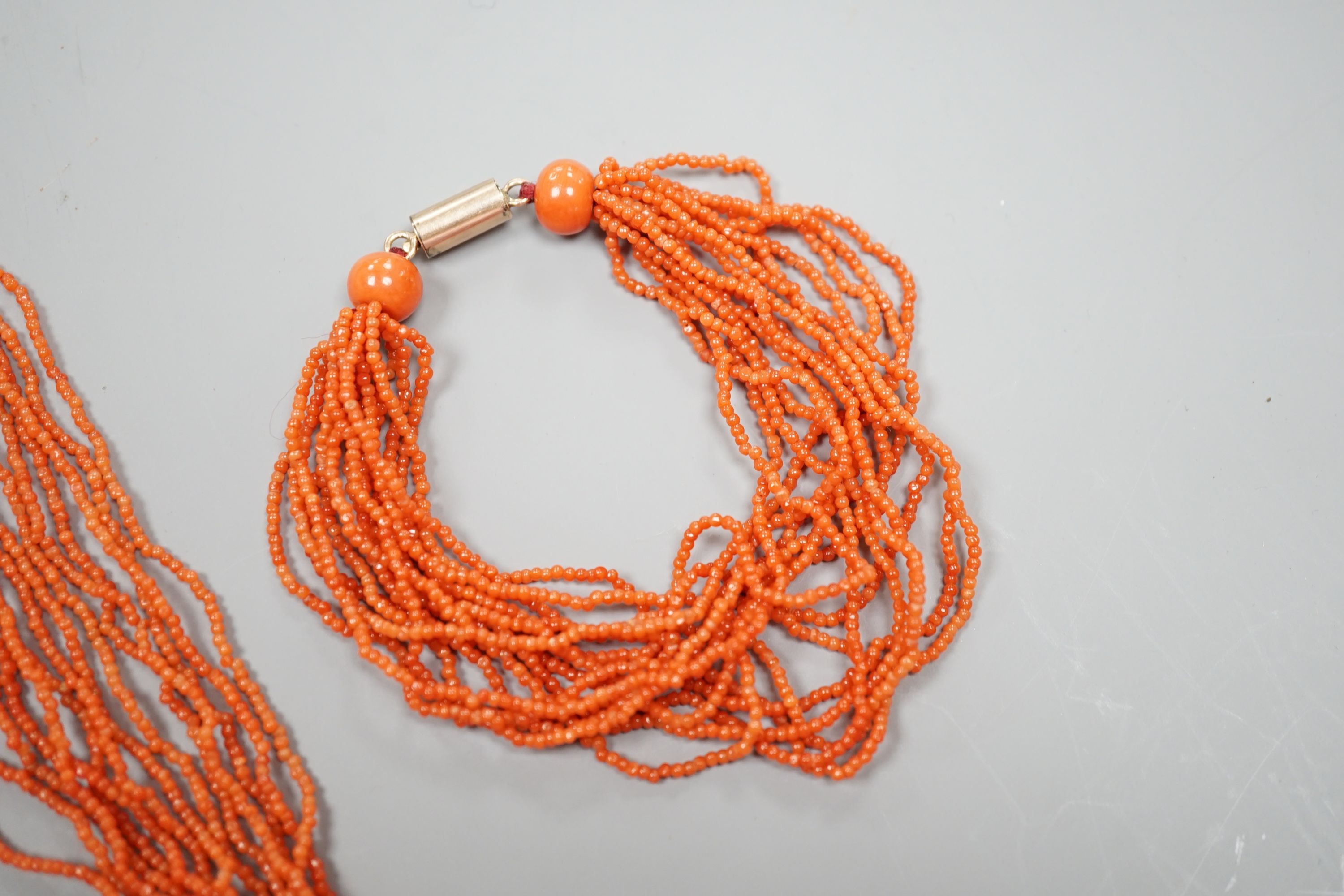 A multi strand coral bead necklace, 39cm and matching bracelet, 15.5cm, both with yellow metal barrel shaped clasps.